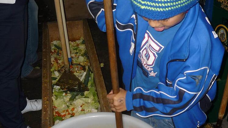 Bastian Buckreus ist mit Feuereifer bei der Sache: Er stopft die fein zerkleinerten Rumm - denn sie müssen ganz dicht im Fass eingestampft sein.  Fotos: Sonja Adam