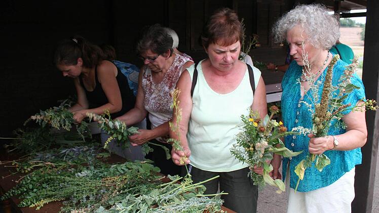 Karin Seubert (rechts) beim Binden des Wurzbüschels mit einer Kursteilnehmerin. Die Königskerze bildet immer den Mittelpunkt des Kräuterbüschels. Fotos: Evi Seeger