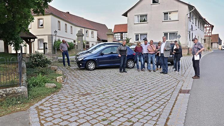 Auf dieser Pflasterfläche an der evangelischen Kirche in Memmelsdorf soll ein Behindertenparkplatz ausgewiesen und der Zugang zur Kirche für Rollstuhl- und Rollatorfahrer verbessert werden, befand der Bauausschuss mit Bürgermeister Helmut Dietz (Vierter von rechts).Helmut Will