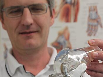 Chefarzt Andreas Suckel von der Kronacher Klinik zeigt an der Nachbildung eines menschlichen Gelenks, wo die Verletzungsrisiken bei manchen Sportarten liegen. Foto: Marco Meißner