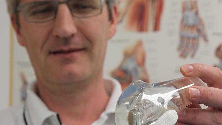 Chefarzt Andreas Suckel von der Kronacher Klinik zeigt an der Nachbildung eines menschlichen Gelenks, wo die Verletzungsrisiken bei manchen Sportarten liegen. Foto: Marco Meißner