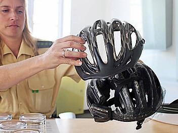 Michaela Rosenthal zeigt einen Fahrradhelm nach einem Unfall. Fotos: Evi Seeger