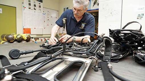 Otmar Mangold demontiert das Tragegestell vom Atemschutzgerät.