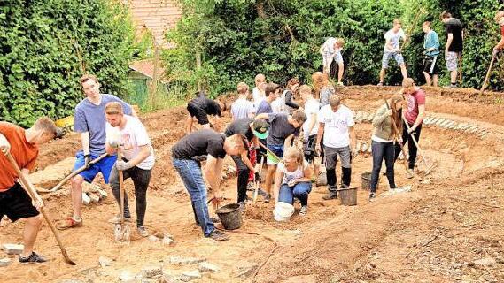 Die Schüler der zehnten Klasse modellieren den neuen großen Gartenteich.  Foto: Günther Geiling