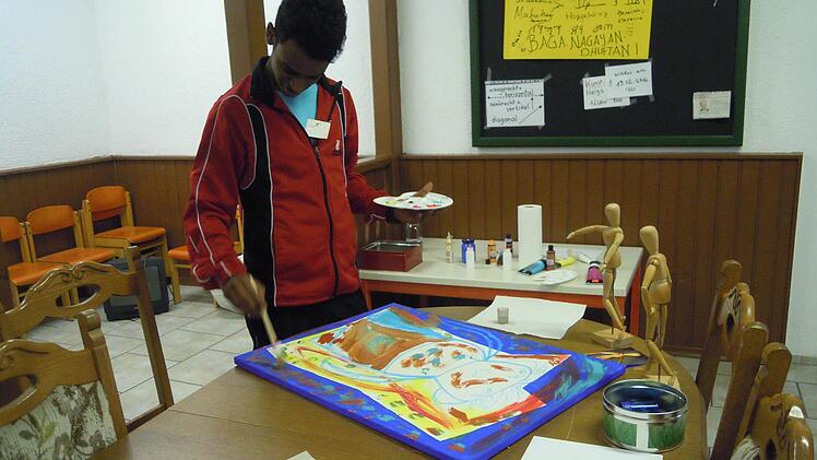 Ein junger Workshop-Teilnehmer ist ganz vertieft in das Malen. Foto: Julia Raab