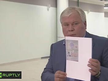 Anatoly Kucherena, Anwalt von Edward Snowden, zeigt die Papiere, die es dem Geheimdienstexperten erlauben, in Russland zu bleiben. Foto: RT PUPTLY/dpa