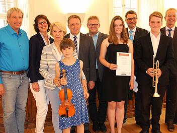 Die Preisträger des Ruckdeschelpreises Elisabeth Schindele (vorn mit Geige), Julian Neubrandt (mit Trompete) und Laura Meile (Vierte v. r.) sowie Margit Ruckdeschel (Dritte v. l.), Oberbürgermeister Henry Schramm (Fünfter v. l.), sein Stellvertreter Frank Wilzok (Fünfter v. r.), Förderverbandsvorsitzende Anja Gimpel-Henning (Zweite v. l.) und Musikschulleiter Harald Streit (Dritter v. l.) sowie die stolzen Eltern Fotos: K. Müller-Sanke