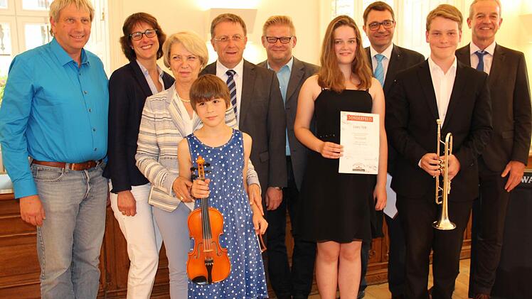 Die Preisträger des Ruckdeschelpreises Elisabeth Schindele (vorn mit Geige), Julian Neubrandt (mit Trompete) und Laura Meile (Vierte v. r.) sowie Margit Ruckdeschel (Dritte v. l.), Oberbürgermeister Henry Schramm (Fünfter v. l.), sein Stellvertreter Frank Wilzok (Fünfter v. r.), Förderverbandsvorsitzende Anja Gimpel-Henning (Zweite v. l.) und Musikschulleiter Harald Streit (Dritter v. l.) sowie die stolzen Eltern Fotos: K. Müller-Sanke