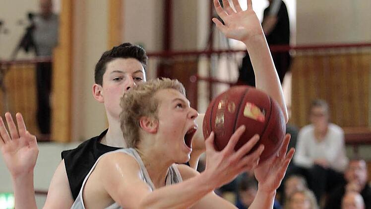 Manuel Feuerpfeil (mit Ball) zieht mit viel Energie zum Korb und ist vom Ulmer Nicolas Bretzel nicht zu stoppen.