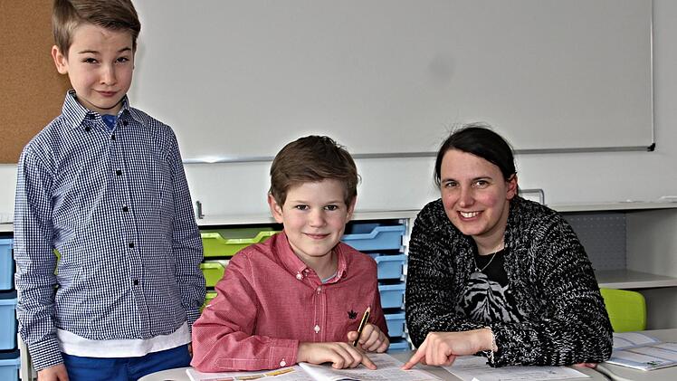Hilfestellung bei den Hausaufgaben gibt Michaela Elflein den Kindern Ferdinand und Eric (von links).