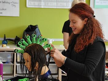 Ihr Talent für das Friseurhandwerk konnten Schülerinnen an Lockenwicklern testen. Foto: Uli Busch