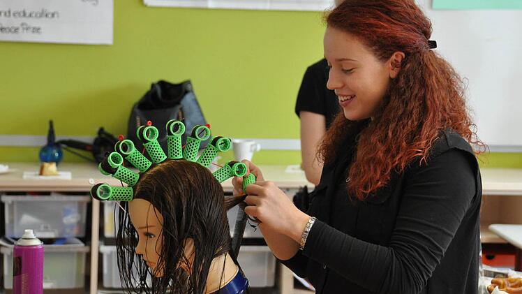 Ihr Talent für das Friseurhandwerk konnten Schülerinnen an Lockenwicklern testen. Foto: Uli Busch