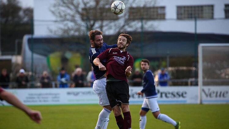 Erlangens Dominik Baier (rotes Trikot) im Kopfballduell mit Tim Rebhan vom VfL Frohnlach. Foto: Lisa Hümmer