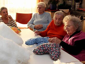 Christl Gohlke erklärt ihrer Nachbarin, wie das Kissenfüllen funktioniert.  Fotos: Johanna Blum