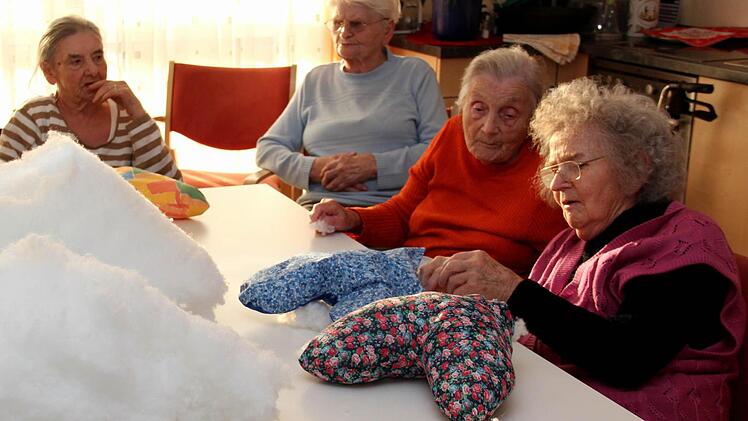 Christl Gohlke erklärt ihrer Nachbarin, wie das Kissenfüllen funktioniert.  Fotos: Johanna Blum
