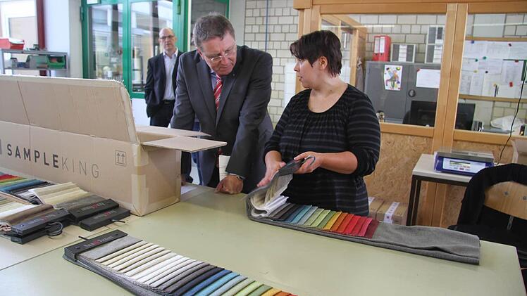 Sonja Hübner erklärt Oberbürgermeister Henry Schramm, wie die Stoffmusterkarten fertig gemacht werden.