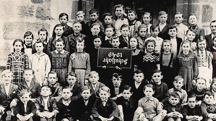 Dieses Gruppenbild der Seßlacher Fünftklässler entstand im Jahr 1949. Bei der Aufnahme waren die Fotografierten noch der irrigen Ansicht, das Schild verkehrt herum halten zu müssen. Foto: privat
