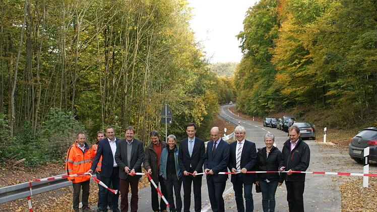 In weniger als zwölf Monaten konnte der zeitlich vorgezogene Ausbau der Kreisstraße HAS 26 von Fabrikschleichach nach Hundelshausen abgeschlossen werden. Die beiden Landräte Wilhelm Schneider und Florian Töpper (Vierter und Fünfter von rechts) schnitten gemeinsam mit Bürgermeister Matthias Bäuerlein (Dritter von links), Manfred Rott (Dritter von rechts) vom Staatlichen Bauamt, dem Leiter des Kreis-Tiefbaus Alfons Schanz (Vierter von links), den Vertretern der Baufirma, des Planungsbüros und d...