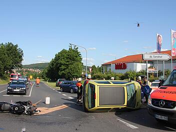 Die Unfallstelle an der Aldi-Kreuzung in Ebern-Sandhof, links die Suzuki, daneben der Twingo des Unfallverursachers hochkant. Der Rettungshubschrauber fliegt eben ein. Foto: Ralf Kestel