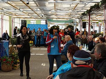 Carmen Kant von der Gärtnerei Schlereth und Moderatorin Irina Hanft verteilen Blumen an die Besucher. Foto: Arkadius Guzy