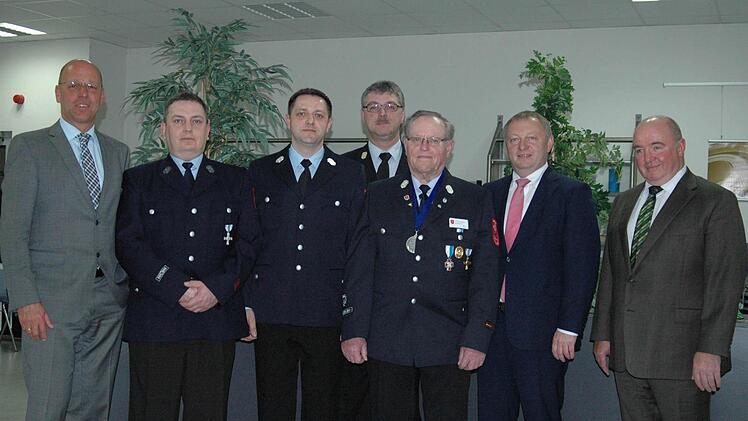 Generationswechsel bei der Werkfeuerwehr: Kommandant Georg Fuchs (3. v. r.) übergibt die Führung der Werkfeuerwehr an Marius Stranzik (3. v. l.). Für 25 Jahre aktiven Dienst wurde Gregor Pasieka (2. v. l.) ausgezeichnet. Es gratulierten (von links) Wildfleckens Bürgermeister Gerd Kleinhenz, Kreisbrandinspektor Marco Brust, Landrat Thomas Bold und Geschäftsführer Manfred Kunert.   Foto: Sebastian Schitt-Mathea