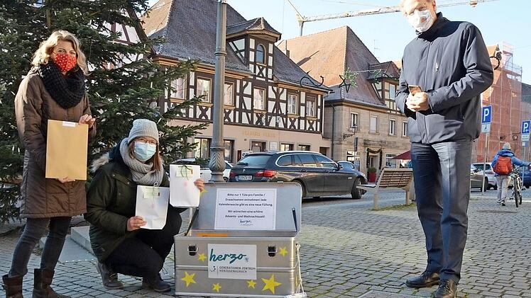 Eva Bauer und Anna-Lena Gumbrecht zeigen Bürgermeister German Hacker die Adventskiste mit den kleinen Geschenken für die Familien.