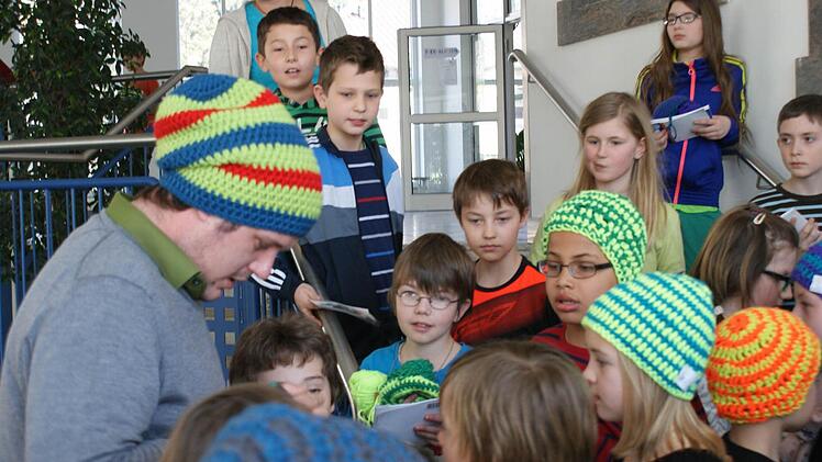 Thomas Jaenisch, einer der beiden Boshi-Erfinder, gibt den Strullendorfer Schülern Autogramme.  Foto: Andrea Spörlein