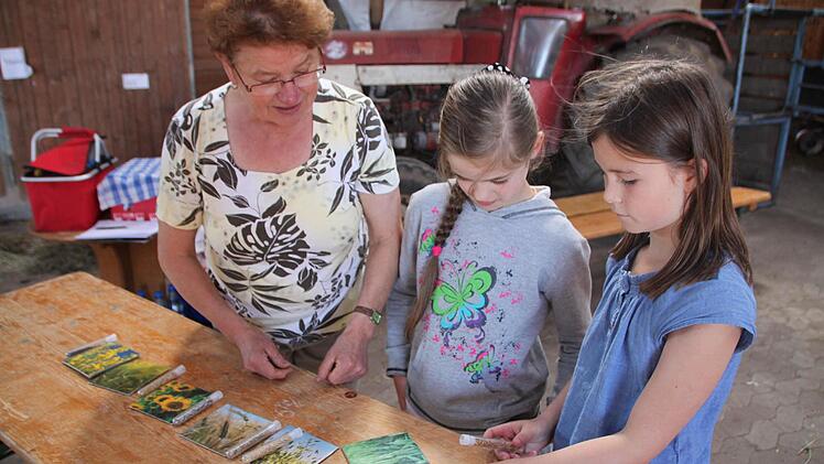 v.l. Rita Jörg zeigt Arina Balashenko und Yara Molitor die Getreidesorten.