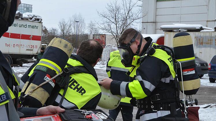 Mit schwerem Atemschutz gehen Feuerwehrleute abwechselnd vor, um die brennende Gasflasche zu kühlen. Fotos: Rainer Lutz