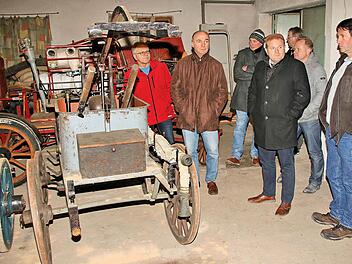 Alte, museumsreife Feuerwehrgeräte lagern in einem Schuppen neben dem Haus Hauptstraße 69 in Poppenlauer. Nach einem Ortstermin war sich der Marktgemeinderat einig darüber, dass das Gebäude samt Schuppen veräußert werden sollte. Unser Bild zeigt Marktgemeinderäte und Bürgermeister Klement in dem Gebäudeteil mit den Feuerwehrgerätschaften. Auf einer Spritze steht "Gemeinde Poppenlauer 1933".  Foto: Dieter Britz