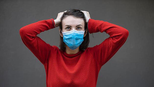 Eine Frau trägt eine OP-Maske.