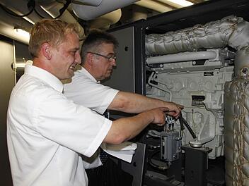 Stadtwerkechef Reinhold Müller (hinten) und Projektleiter Andreas Müller zeigen den Generator.