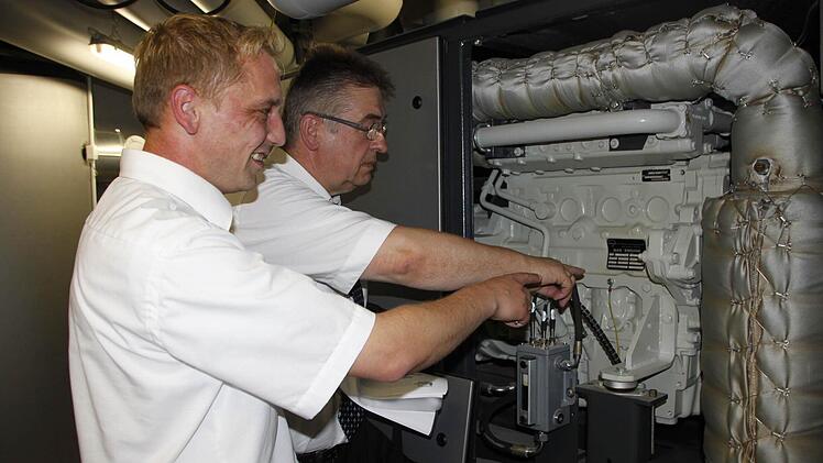 Stadtwerkechef Reinhold Müller (hinten) und Projektleiter Andreas Müller zeigen den Generator.