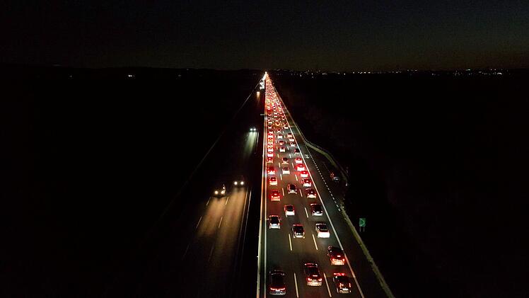 Fahrzeuge stehen auf der Autobahn in Richtung Stadt. Rom-Mailand, Italien. Nacht. Luftaufnahme der Autobahn mit Stau aufgrund des starken Verkehrs nach einem Wochenende außerhalb der Stadt. Weniger anzeigen von ItalyDrones Vehicles stopped on the highway returning to the city. Rome Milan, Italy. Night. Aerial view of the highway with a traffic jam due to heavy traffic after a weekend out of town. Weniger anzeigen