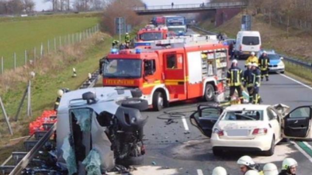Feuerwehrleute stehen neben zwei verungl&uuml;ckten Autos. Bei dem Zusammensto&szlig; eines voll besetzten Taxis mit einem Kleintransporter sind im M&uuml;nsterland zwei Menschen get&ouml;tet worden. Foto: Feuerwehr Gronau