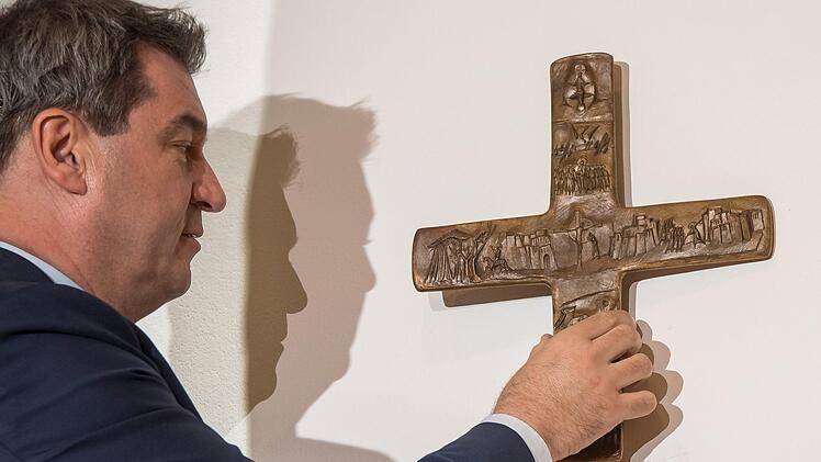Das symbolische erste Kreuz: Markus Söder setzt sein Vorhaben um. In Bayerns Behörden sollen zukünftig Kreuze im Eingangsbereich hängen. Foto: Peter Kneffel/dpa