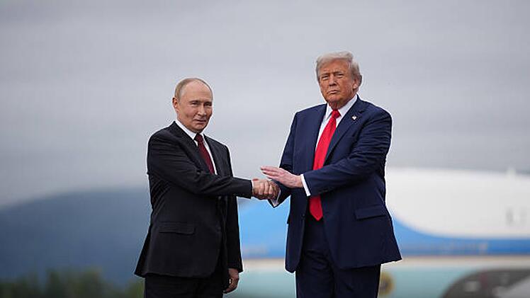 Donald Trump (rechts), Pr&auml;sident der Vereinigten Staaten, begr&uuml;&szlig;t seinen russischen Amtskollegen Wladimir Putin am 15. August 2025 bei ihrem Treffen auf dem Flughafen der "Joint Base" Elmendorf-Richardson in Alaska zu Friedensgespr&auml;chen. Inzwischen h&auml;ngt das Bild im Wei&szlig;en Haus.