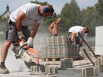 Auge fürs Detail: Jens Fischer passt die Pflastersteine mit der Flex zentimetergenau an. Fotos: Ulrike Müller