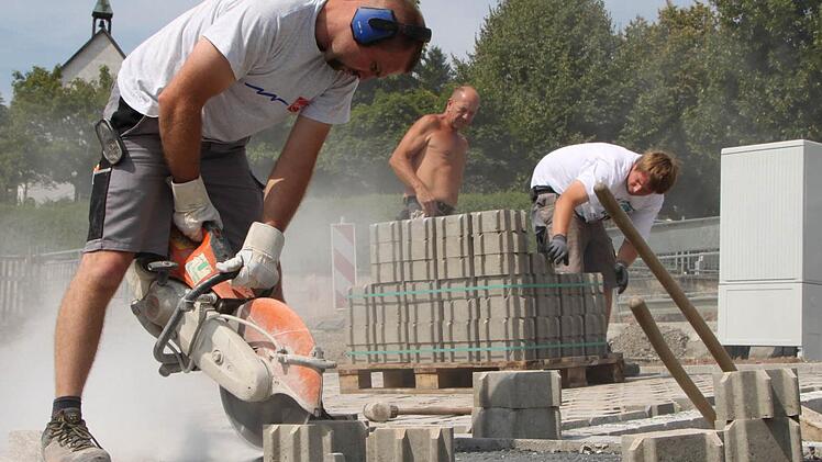 Auge fürs Detail: Jens Fischer passt die Pflastersteine mit der Flex zentimetergenau an. Fotos: Ulrike Müller
