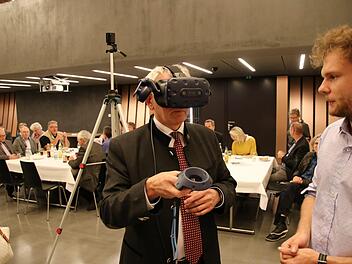 Landrat Johann Kalb blickt mit einer digitalen Brille in virtuelle Visionen einer Mobilität mit autonom fahrenden Autos - und ohne Parkplätze. Foto: Sebastian Schanz