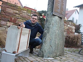 Bürgermeister Armin Warmuth mit dem Koffer aus Metall und Beton, der am Seelhausplatz in der Hammelburger Innenstadt bereits aufgestellt ist. Foto: Ralf Ruppert