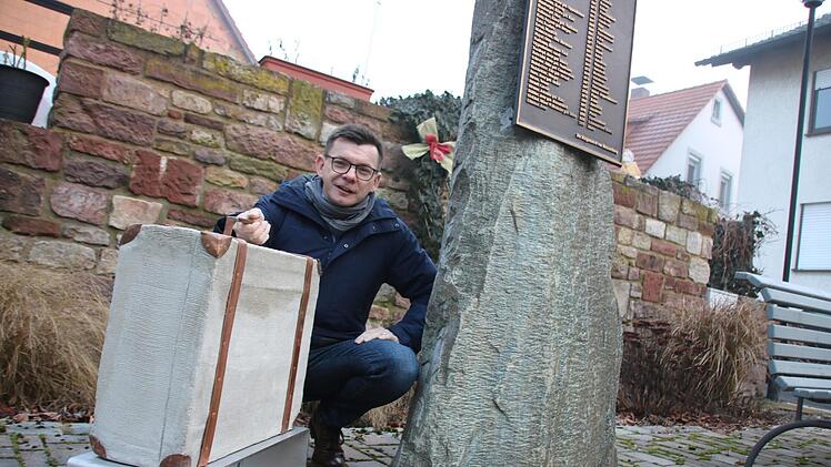 Bürgermeister Armin Warmuth mit dem Koffer aus Metall und Beton, der am Seelhausplatz in der Hammelburger Innenstadt bereits aufgestellt ist. Foto: Ralf Ruppert