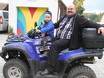 Pfarrer Christian Schmidt - mit seinem Sohn Felix (5) liebt ausgefallene Fahrzeuge wie sein Quad. Foto: Sonja Adam