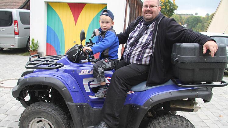 Pfarrer Christian Schmidt - mit seinem Sohn Felix (5) liebt ausgefallene Fahrzeuge wie sein Quad. Foto: Sonja Adam