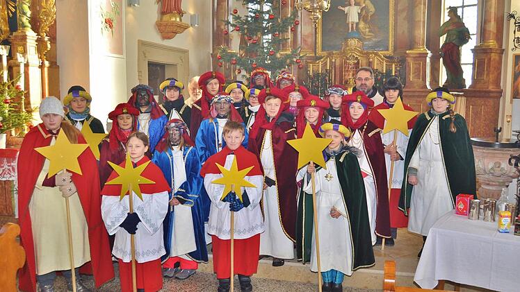Am Dreikönigstag entsandte Pfarrer Kosma Rejmer (hinten rechts) die Sternsinger nach Mainroth und Mainklein. Die Diasporaorte hatten sie nach der Aussendungsfeier durch Diakon Herbert Mayer (hinten links) schon am Tag vorher besucht. Foto: Ingrid Kohles