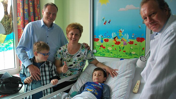 Schon einmal hatte Helmut Zolleis (l.) einem rumänischen Kind geholfen: 2014 besuchte er mit seinem Sohn Noah und Prof. Maximilian Stehr (r.) den gerade operierten Rades und dessen Mutter Claudia. Foto: privat
