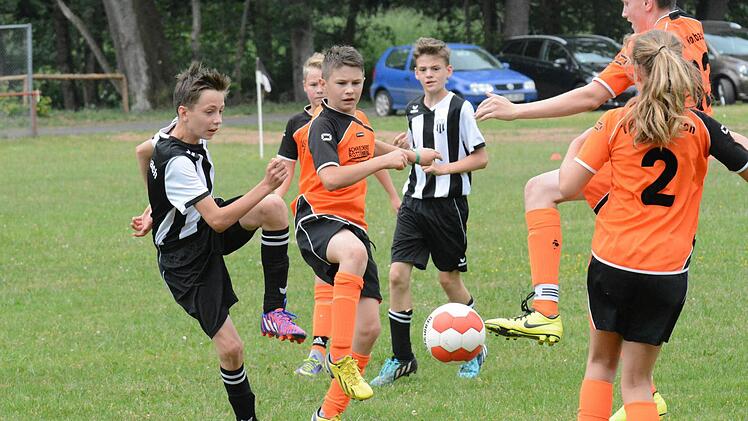 Der Unruhestifter: Für Aufregung in der Wollbacher Abwehr um Chiara Sophie Matthes und Fabio Ziegler (hinten rechts) sorgt David Pasieka (links) von der U-13 der JFG Sinntal-Schondratal III. Foto: ssp