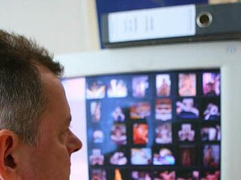 Ein Fahnder sitzt vor einem Computerschirm mit Kinderpornos.Symbolfoto: Peter Förster/dpa