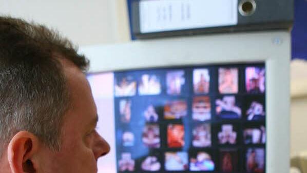 Ein Fahnder sitzt vor einem Computerschirm mit Kinderpornos.Symbolfoto: Peter Förster/dpa