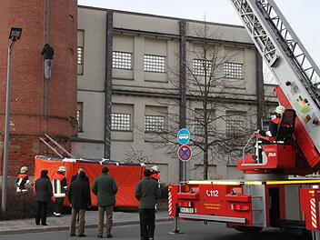Der Asylbewerber hat aufgegeben: Er klettert vom Spinnerei-Schlot wieder nach unten, wo er sich in 30 Metern Höhe eine Stunde lang festgeklammert und droht hat, in die Tiefe zu springen. Fotos: Stephan Tiroch